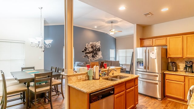 kitchen featuring ceiling fan with notable chandelier, sink, light hardwood / wood-style flooring, light stone countertops, and stainless steel appliances