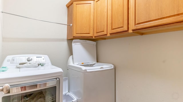 laundry room featuring cabinets and washer and dryer