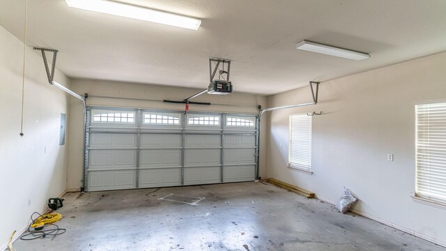 garage featuring electric panel and a garage door opener