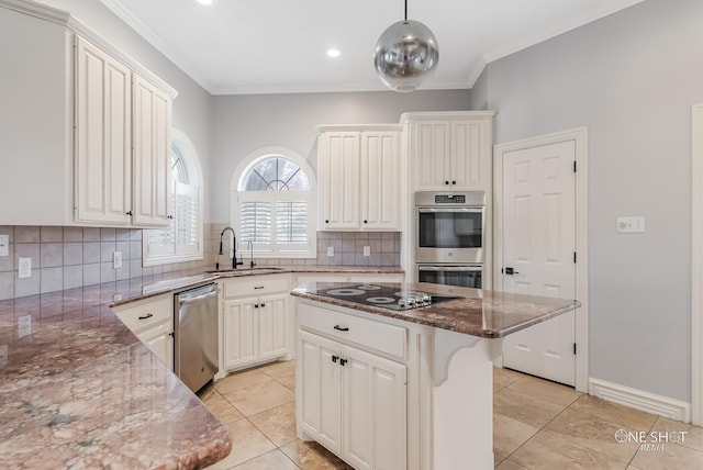 kitchen with stone counters, appliances with stainless steel finishes, decorative light fixtures, sink, and a center island