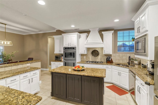 kitchen with appliances with stainless steel finishes, decorative light fixtures, a center island, and white cabinets