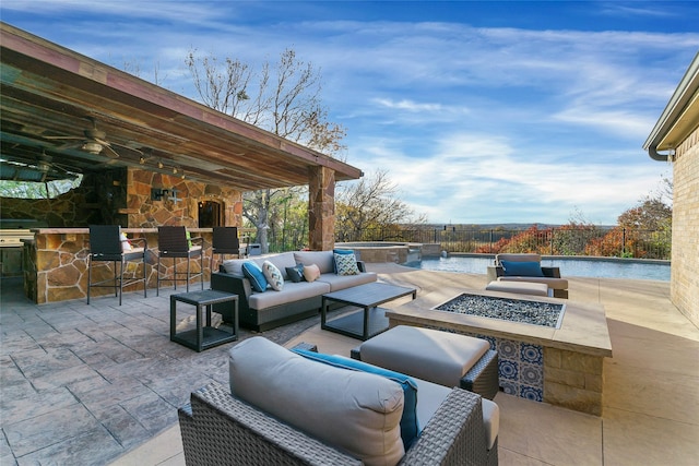 view of patio with an in ground hot tub, an outdoor living space with a fireplace, and an outdoor bar