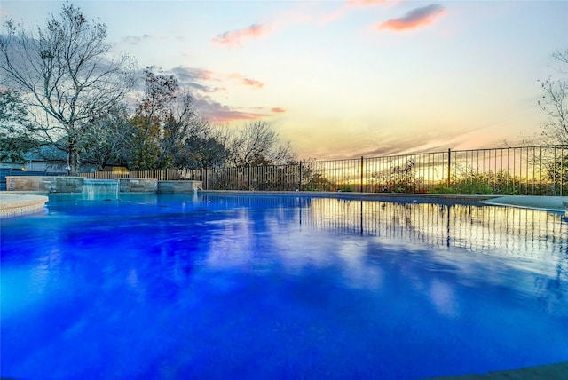 view of pool at dusk