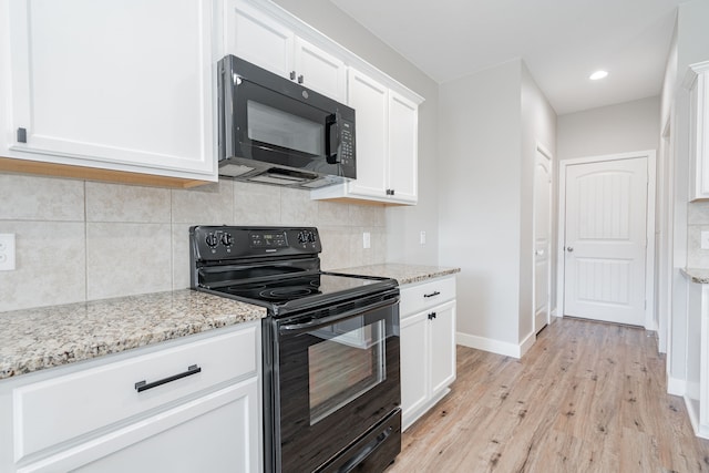 kitchen with black appliances, white cabinets, light wood-type flooring, and light stone counters