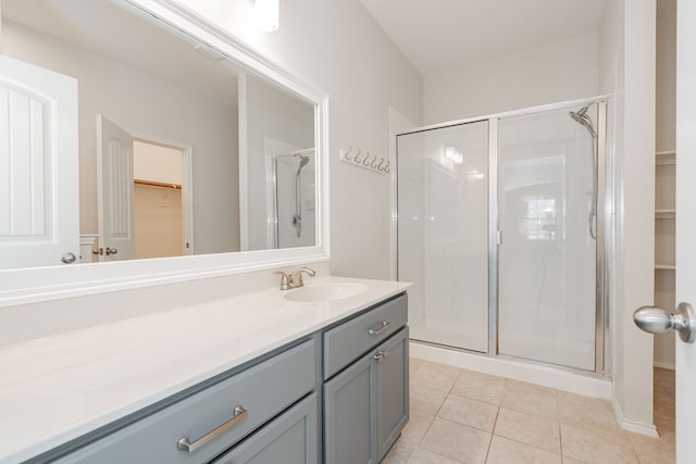 bathroom featuring tile patterned floors, vanity, and a shower with door