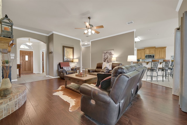 living room with crown molding, ceiling fan, and hardwood / wood-style flooring