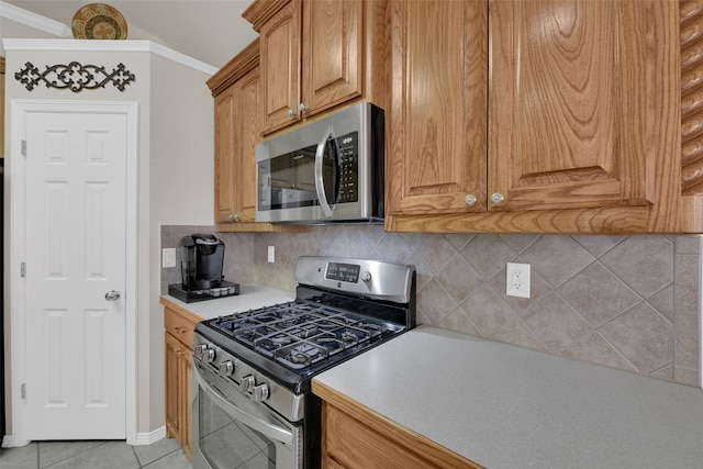 kitchen featuring decorative backsplash, light tile patterned floors, stainless steel appliances, and ornamental molding