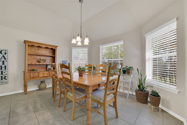 dining space featuring a healthy amount of sunlight, an inviting chandelier, lofted ceiling, and light tile patterned flooring