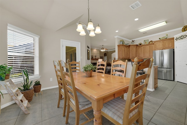 tiled dining room featuring ceiling fan with notable chandelier and ornamental molding