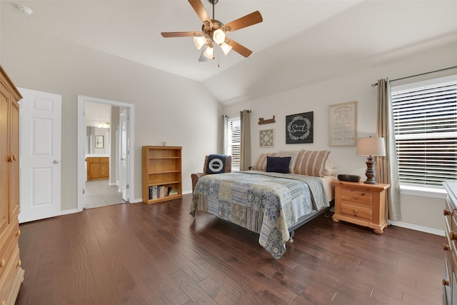 bedroom featuring dark hardwood / wood-style flooring, ensuite bath, ceiling fan, and lofted ceiling