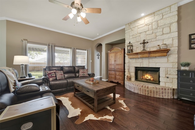 living room with ceiling fan, a fireplace, dark hardwood / wood-style floors, and ornamental molding