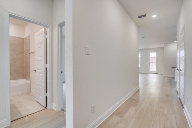 corridor with light wood-style floors, baseboards, visible vents, and recessed lighting