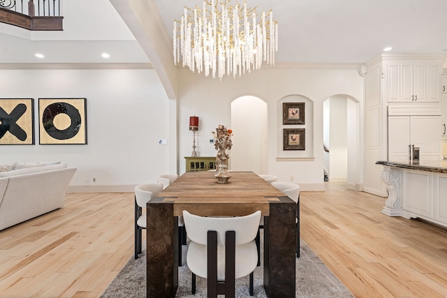 dining area with a chandelier, light hardwood / wood-style flooring, and ornamental molding