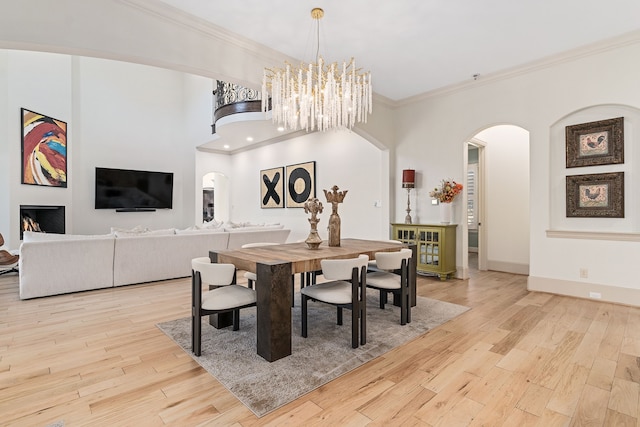 dining room with crown molding and light hardwood / wood-style floors