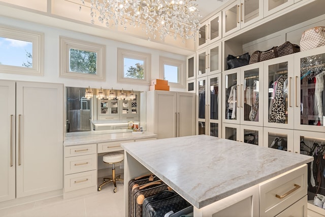 walk in closet with light tile patterned flooring and an inviting chandelier