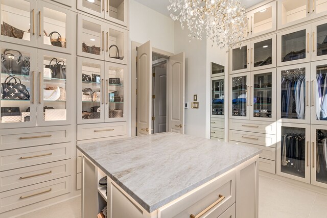 spacious closet featuring light tile patterned floors and a notable chandelier