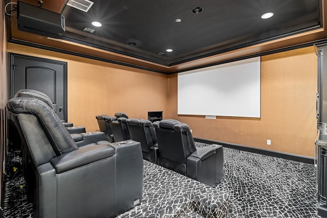 cinema room featuring a raised ceiling, carpet floors, and ornamental molding