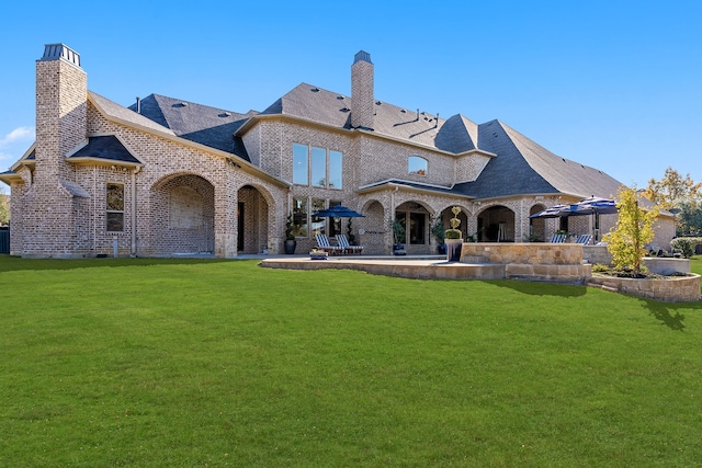 back of property featuring a patio and a lawn