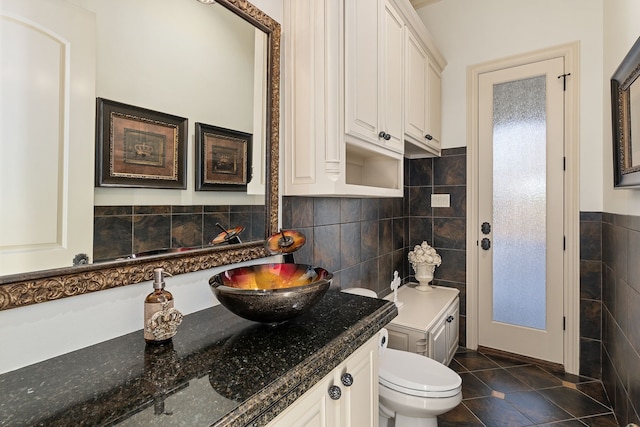 bathroom with tile patterned floors, vanity, tile walls, and toilet