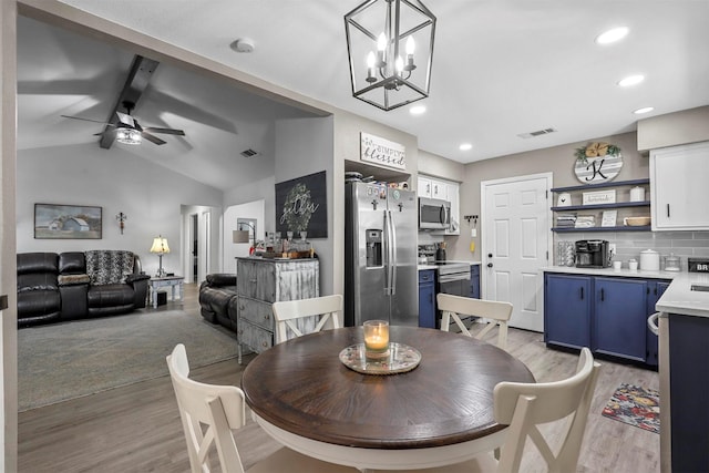 dining area featuring ceiling fan with notable chandelier, lofted ceiling with beams, and light hardwood / wood-style flooring