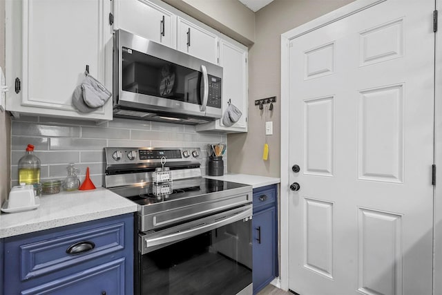 kitchen with blue cabinets, stainless steel appliances, and white cabinetry