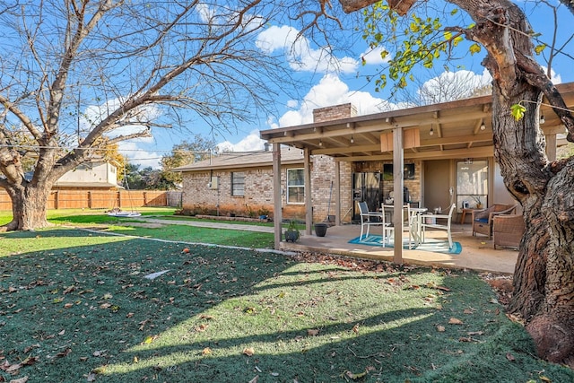 rear view of house with a patio and a lawn