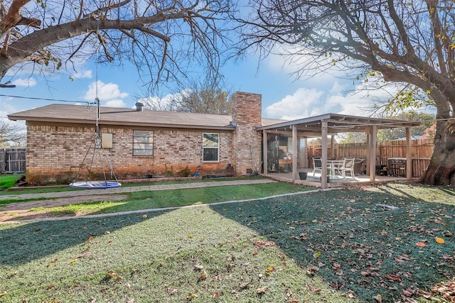 back of property featuring a lawn and a patio area