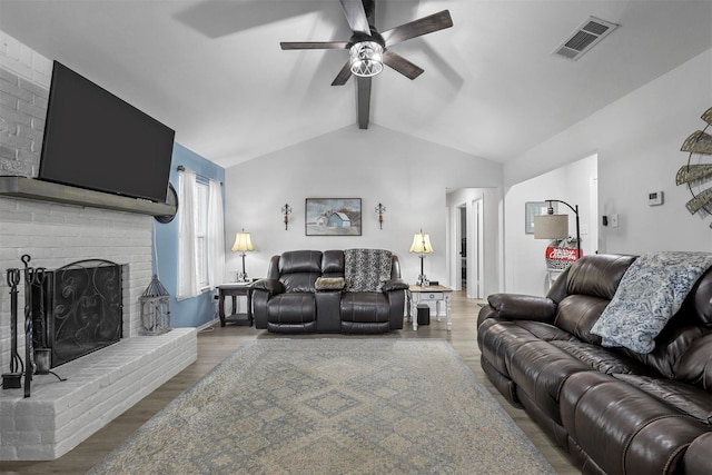 living room with vaulted ceiling with beams, a brick fireplace, ceiling fan, and hardwood / wood-style flooring