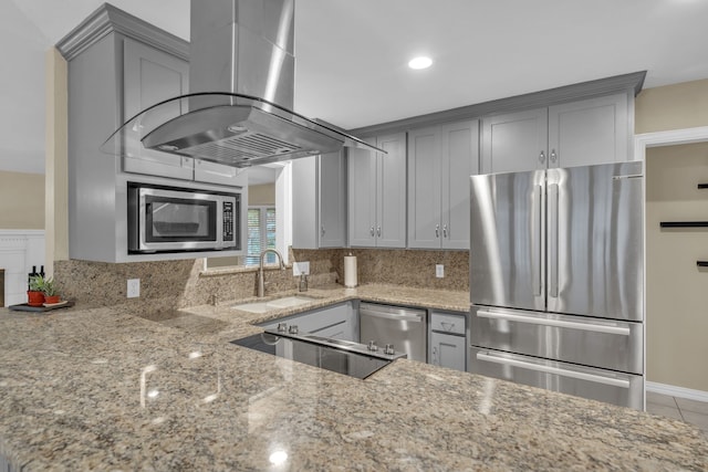 kitchen featuring island range hood, sink, gray cabinetry, stainless steel appliances, and light stone countertops