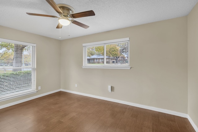 unfurnished room with ceiling fan, hardwood / wood-style floors, a textured ceiling, and a wealth of natural light