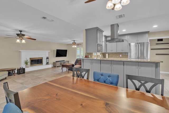 dining area featuring ceiling fan, sink, and light tile patterned floors