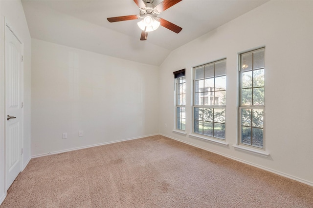 empty room with vaulted ceiling, ceiling fan, and carpet