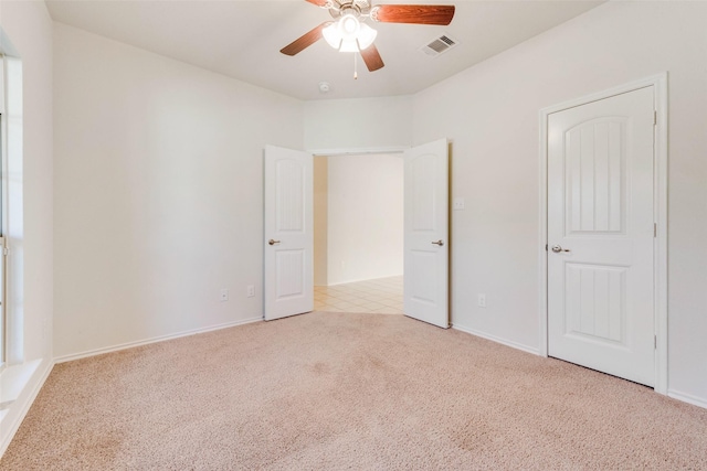 unfurnished bedroom featuring light colored carpet and ceiling fan