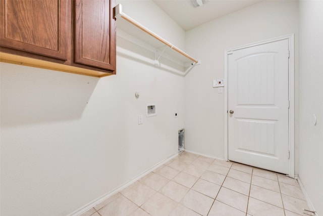 clothes washing area featuring electric dryer hookup, cabinets, washer hookup, light tile patterned flooring, and hookup for a gas dryer