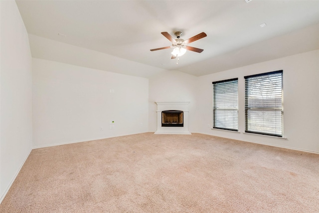 unfurnished living room featuring vaulted ceiling, light carpet, and ceiling fan