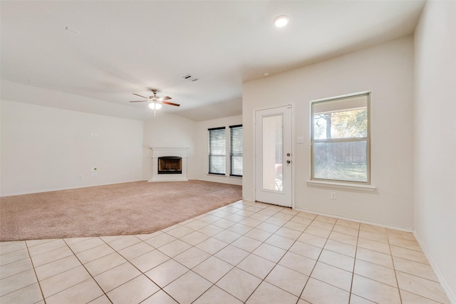 unfurnished living room with a healthy amount of sunlight, light colored carpet, and ceiling fan