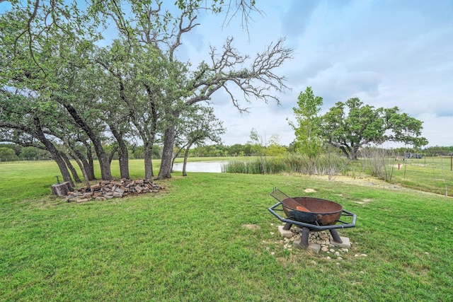 view of yard featuring an outdoor fire pit and a water view