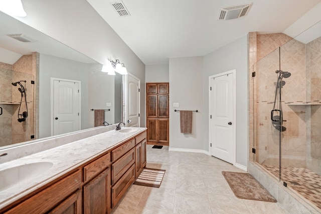 bathroom featuring tile patterned flooring, vanity, and a shower with shower door