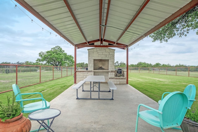 view of patio with a gazebo, a rural view, and an outdoor stone fireplace