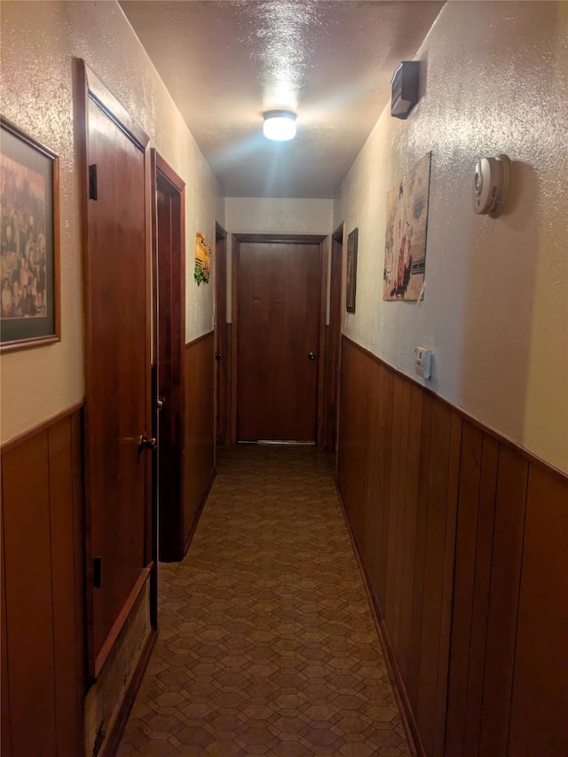 hallway featuring wooden walls