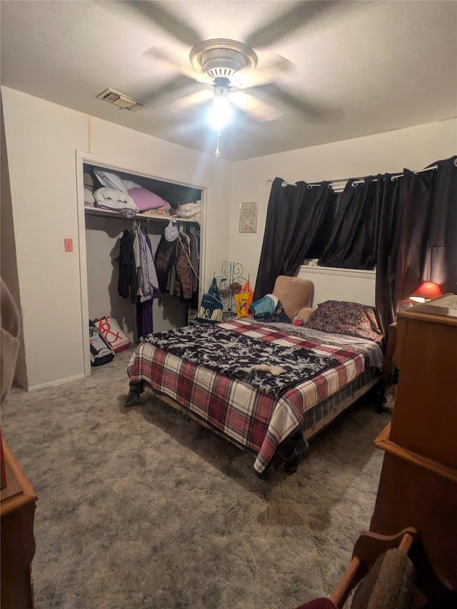 bedroom with dark colored carpet, ceiling fan, and a closet