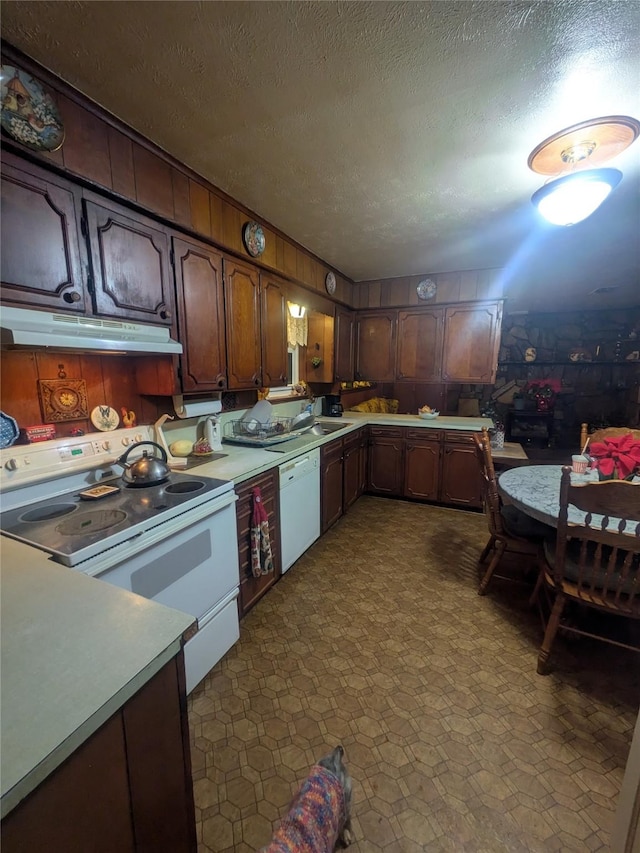 kitchen featuring a textured ceiling, white appliances, and dark brown cabinets