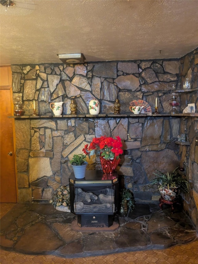 details featuring a textured ceiling and a wood stove