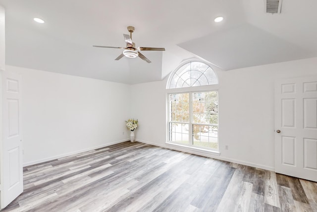 spare room featuring ceiling fan, light hardwood / wood-style floors, and vaulted ceiling