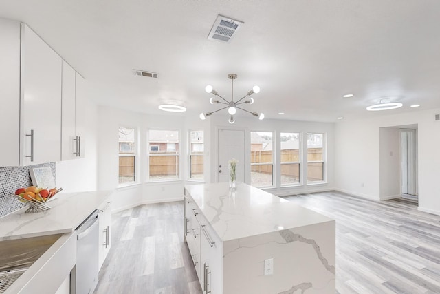 kitchen featuring white cabinets, light wood-type flooring, a kitchen island, and dishwasher