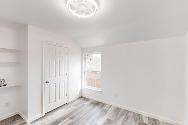 unfurnished bedroom with lofted ceiling and light hardwood / wood-style flooring