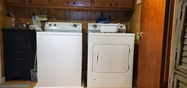 laundry room with washer and dryer, cabinets, and light wood-type flooring