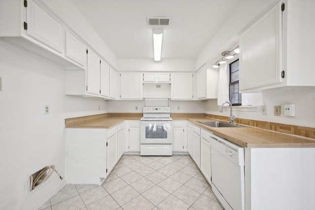 kitchen with white cabinetry, light tile patterned flooring, white appliances, and sink