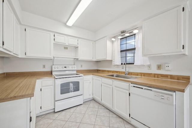 kitchen with light tile patterned floors, white appliances, white cabinetry, and sink