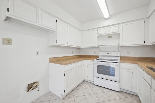 kitchen with white cabinets, white electric range, and light tile patterned floors